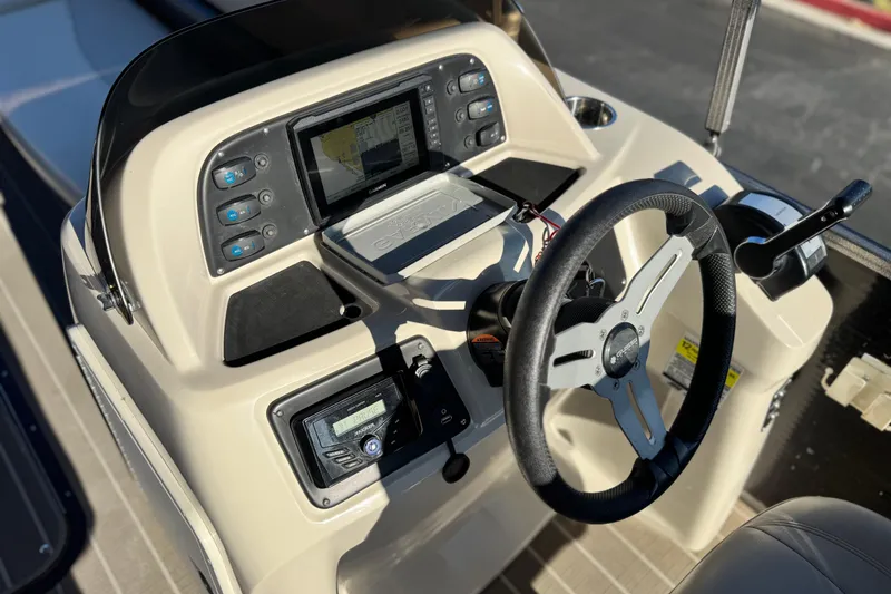 Slide: The Image of 2021 Manitou 23 Aurora LE Standard boat dashboard with steering wheel and control panel. - 24