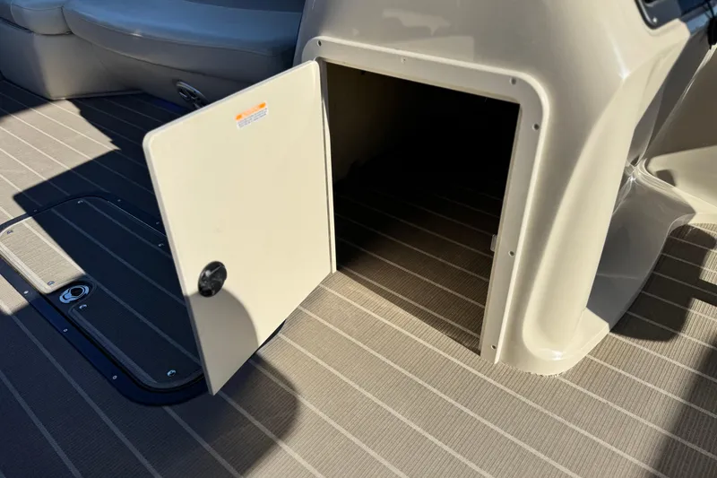 Slide: The Image of 2021 Manitou 23 Aurora LE Standard boat storage compartment with open door on deck. - 25