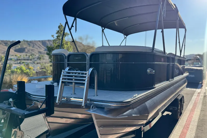 Slide: The Image of 2021 Manitou 23 Aurora LE Standard pontoon boat on trailer, sunny outdoor setting. - 3