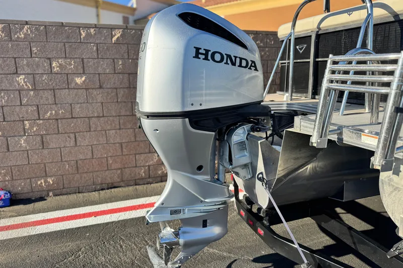 Slide: The Image of 2021 Manitou 23 Aurora LE Standard with Honda outboard motor, parked outdoors. - 7