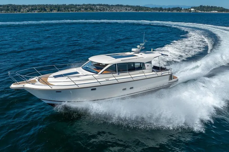 Slide: The Image of Nimbus 405 Coupé 2022 cruising on open water, creating a dynamic wake. - 12