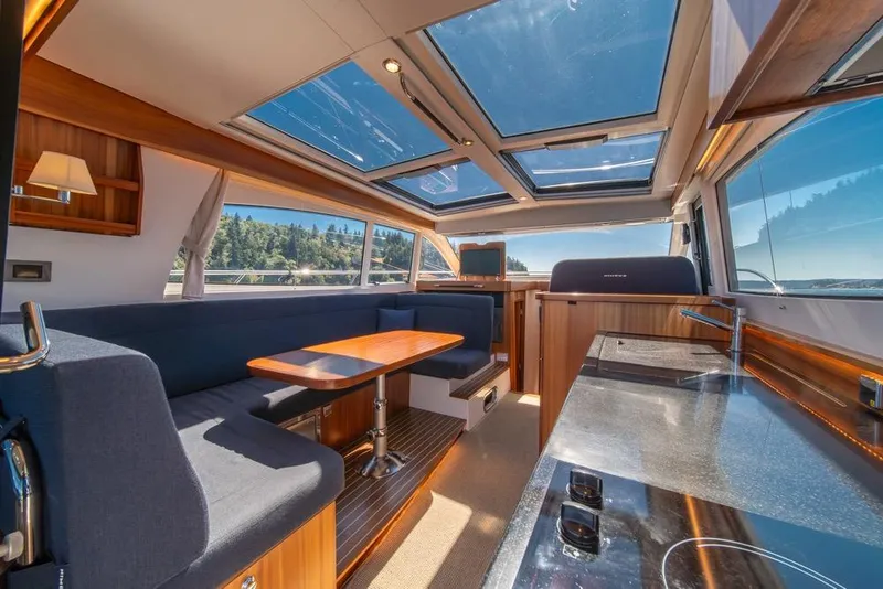 Slide: The Image of Luxurious interior of 2022 Nimbus 405 Coupé yacht with panoramic windows and modern furnishings. - 13