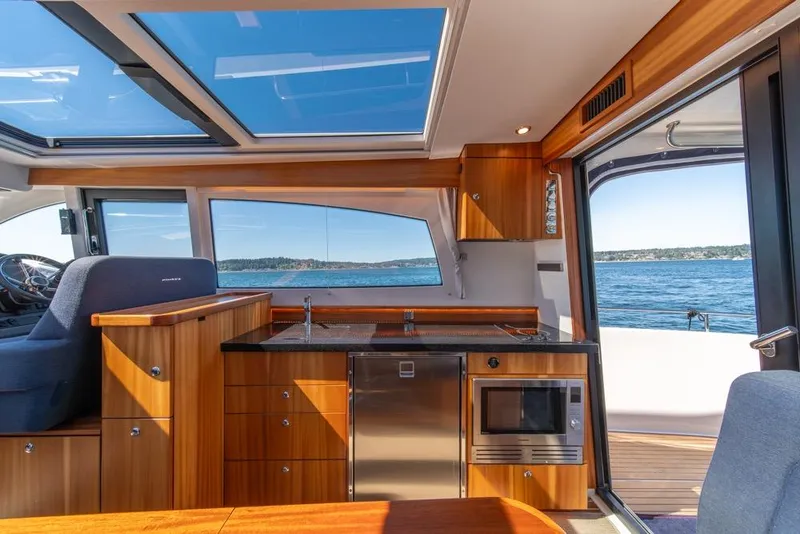 Slide: The Image of Interior of 2022 Nimbus 405 Coupé yacht with modern kitchen and ocean view. - 17
