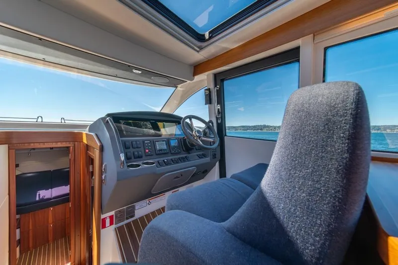 Slide: The Image of Interior of 2022 Nimbus 405 Coupé yacht with helm, seating, and ocean view. - 19