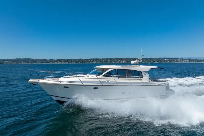 Slide: The Image of 2022 Nimbus 405 Coupé cruising on open water under clear blue skies. - 4