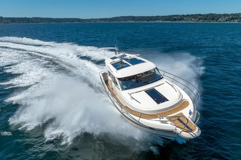 Slide: The Image of 2022 Nimbus 405 Coupé yacht cruising on open water, creating a dynamic wake. - 5