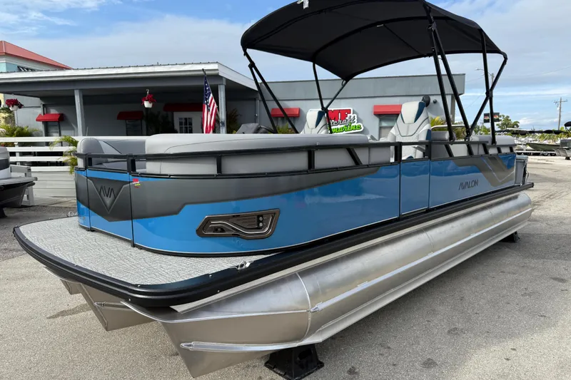 The Image of 2026 Avalon 2385 Venture 85 Quad Lounger Tri Toon boat, blue and gray, docked outdoors. - 27
