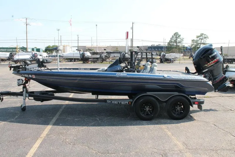 Slide: The Image of 2021 Skeeter ZX225 bass boat with Yamaha engine on trailer in parking lot. - 0
