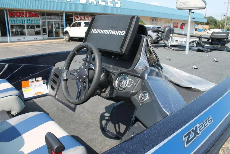 Slide: The Image of 2021 Skeeter ZX225 boat interior with steering wheel and Humminbird display. - 6