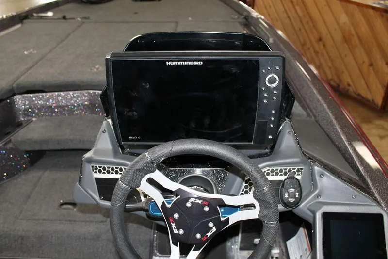 Slide: The Image of 2025 Skeeter FXR21L boat dashboard with Humminbird Helix 12 display and steering wheel. - 10