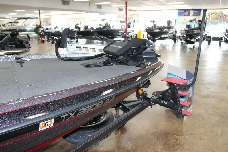 Slide: The Image of 2025 Skeeter FXR21L bass boat displayed in a showroom with trailer attachment. - 2