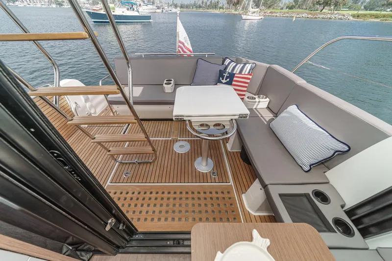 Slide: The Image of 2023 Beneteau Antares 11 Fly boat deck with seating, table, and nautical decor. - 37
