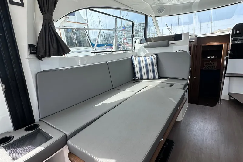 Slide: The Image of Interior of 2023 Beneteau Antares 11 Fly with gray seating and striped pillow. - 72