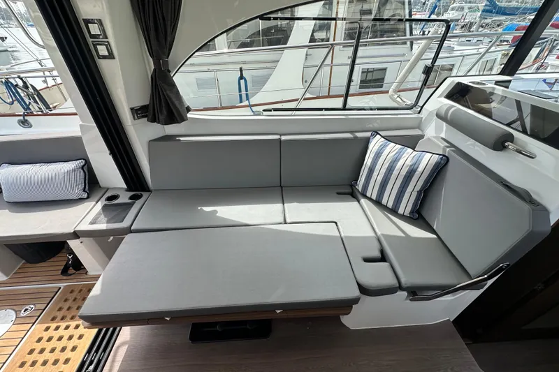Slide: The Image of 2023 Beneteau Antares 11 Fly interior with gray seating and striped cushions. - 73