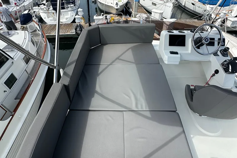 Slide: The Image of 2023 Beneteau Antares 11 Flybridge with cushioned seating and helm, docked at marina. - 74
