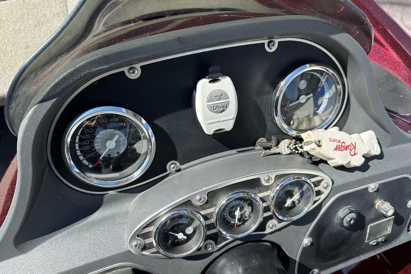 Slide: The Image of Dashboard of a 2010 Ranger 178 VS boat with gauges and keychain. - 17