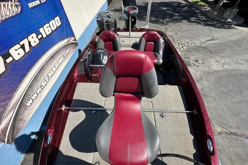 Slide: The Image of 2010 Ranger 178 VS boat with red and gray seating, parked outdoors. - 25