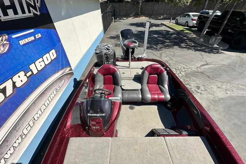 Slide: The Image of 2010 Ranger 178 VS boat with red and gray seating, parked outdoors. - 26