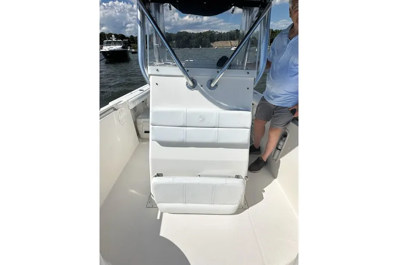 Slide: The Image of 2007 Edgewater 245CC boat interior with seating and console on a sunny day. - 13