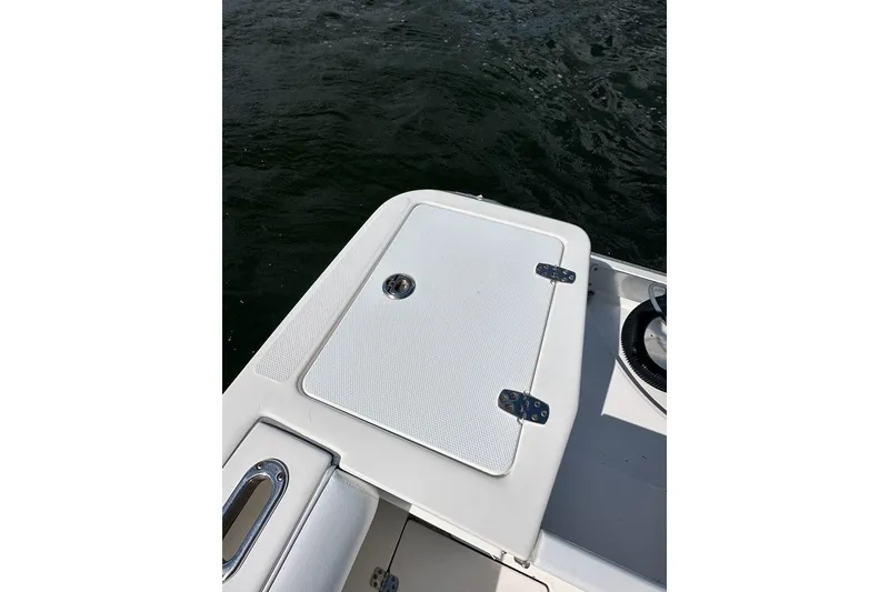 Slide: The Image of 2007 Edgewater 245CC boat deck with storage compartment, near water. - 19