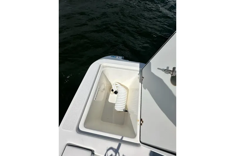 Slide: The Image of Open storage compartment on 2007 Edgewater 245CC boat with coiled hose. - 20