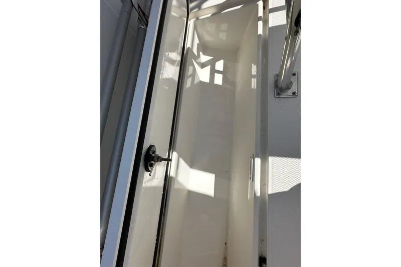 Slide: The Image of 2007 Edgewater 245CC boat storage compartment with latch and metal support. - 22