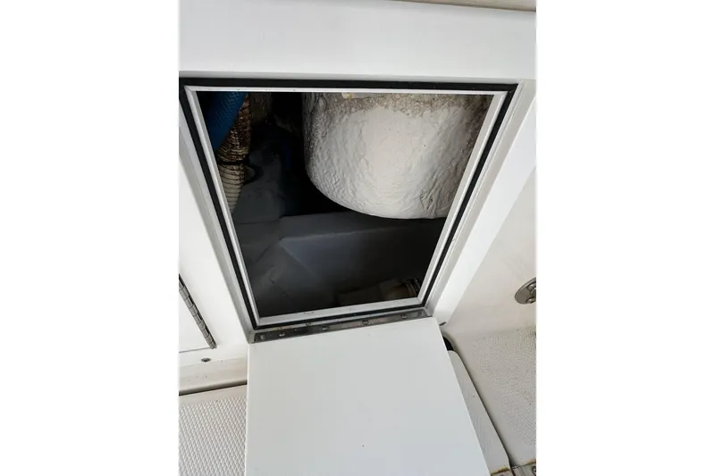 Slide: The Image of Open hatch on 2007 Edgewater 245CC boat, revealing interior compartment. - 24