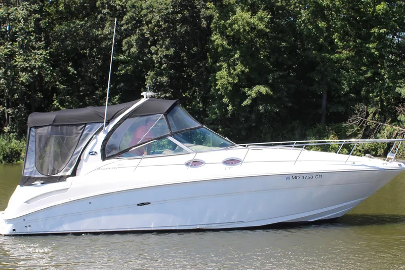 The Image of 2005 Sea Ray 300 Sundancer boat on calm water, surrounded by lush greenery. - 0
