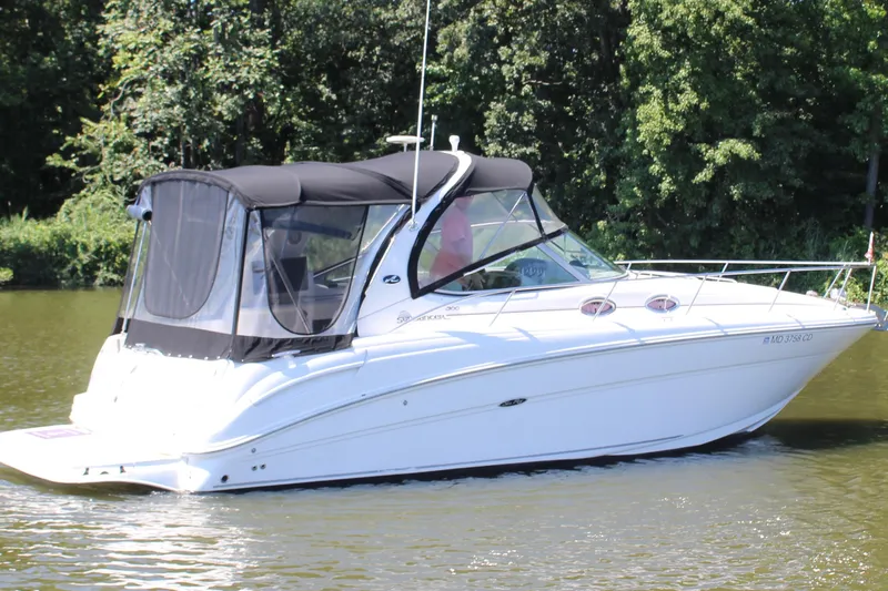 Slide: The Image of 2005 Sea Ray 300 Sundancer boat cruising on a calm river with lush greenery. - 1