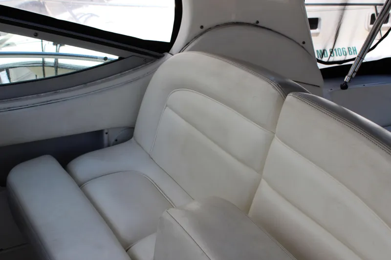 Slide: The Image of Interior seating of 2005 Sea Ray 300 Sundancer boat, featuring white leather upholstery. - 16