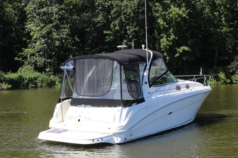 Slide: The Image of 2005 Sea Ray 300 Sundancer boat on a calm lake with forest backdrop. - 2