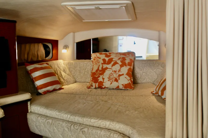 Slide: The Image of Interior cabin of 2005 Sea Ray 300 Sundancer with cozy bedding and decorative pillows. - 21