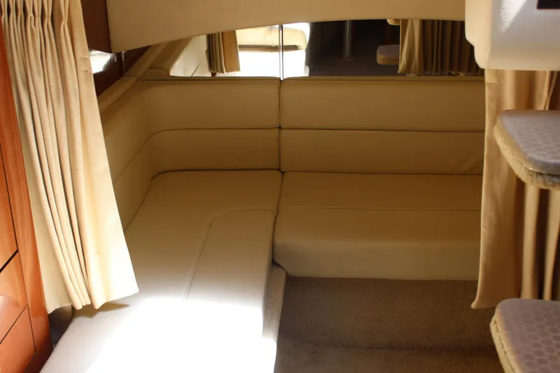 Slide: The Image of Interior of 2005 Sea Ray 300 Sundancer with beige seating and curtains. - 23