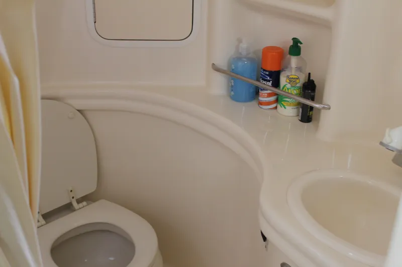 Slide: The Image of Compact bathroom in 2005 Sea Ray 300 Sundancer boat with toiletries and sink. - 24