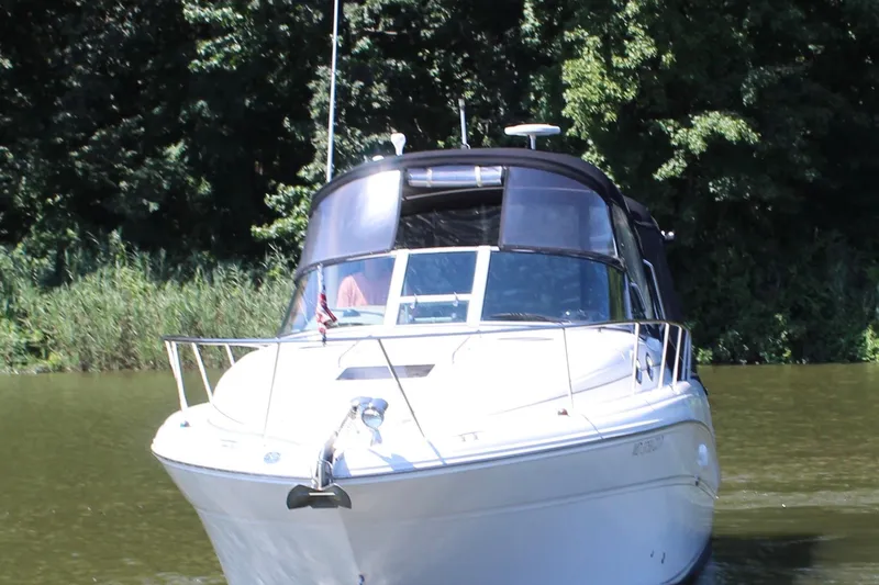 Slide: The Image of 2005 Sea Ray 300 Sundancer cruising on a calm river with lush greenery. - 4