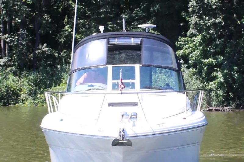 Slide: The Image of 2005 Sea Ray 300 Sundancer cruising on a calm river, surrounded by lush greenery. - 6