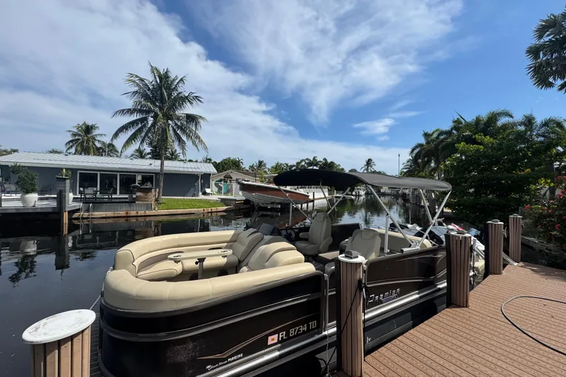 Slide: The Image of 2022 Premier Solaris 230 boat cruising near luxury yachts and palm trees. - 0