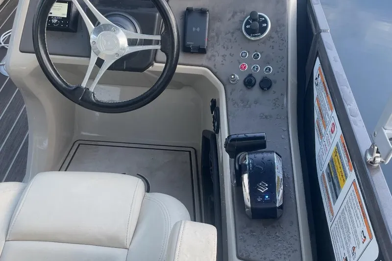 Slide: The Image of Premier Solaris 230 boat interior with white seating, docked near jet skis, 2022 model. - 15