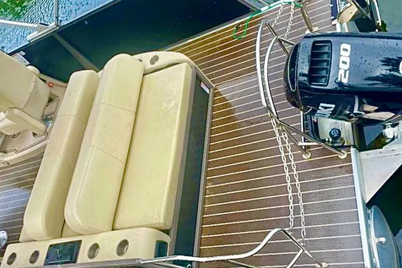 Slide: The Image of 2022 Premier Solaris 230 boat interior with white seating, docked near jet skis. - 16