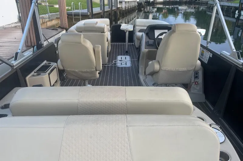 Slide: The Image of Interior of 2022 Premier Solaris 230 boat with beige seating and modern dashboard. - 25