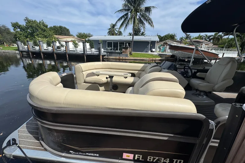 Slide: The Image of 2022 Premier Solaris 230 pontoon boat on water, featuring beige seating and canopy. - 3