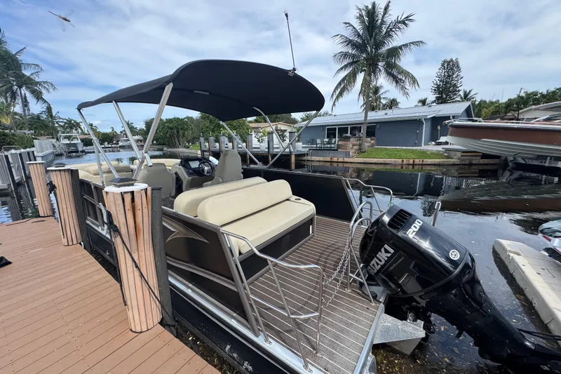 Slide: The Image of 2022 Premier Solaris 230 pontoon boat interior with beige seating and steering console. - 32