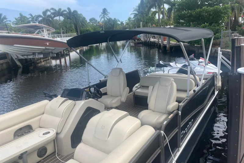 Slide: The Image of 2022 Premier Solaris 230 pontoon boat docked, featuring a Suzuki 200 outboard motor. - 4