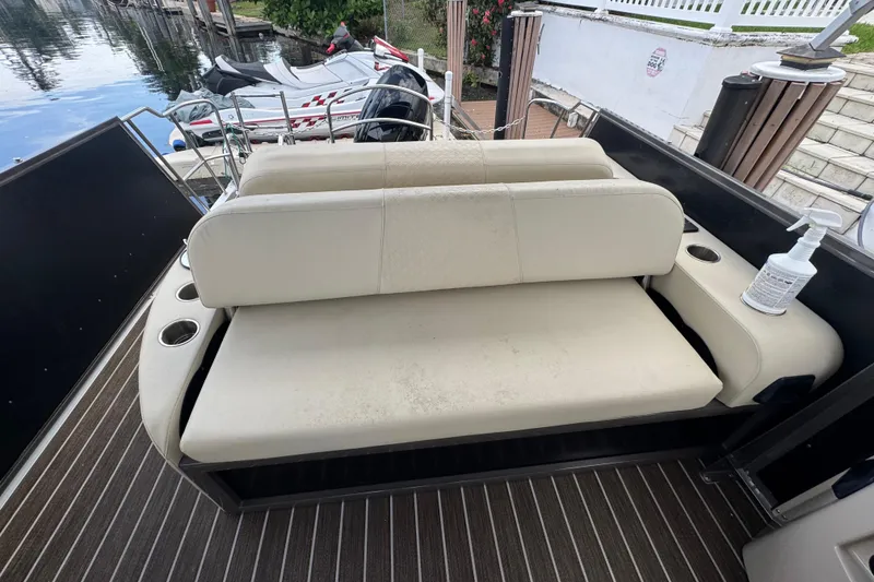 Slide: The Image of 2022 Premier Solaris 230 boat interior with white seats, docked by a canal. - 64