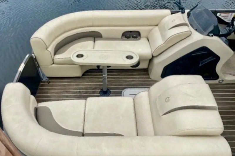 Slide: The Image of 2022 Premier Solaris 230 pontoon boat docked by a waterfront home with palm trees. - 7