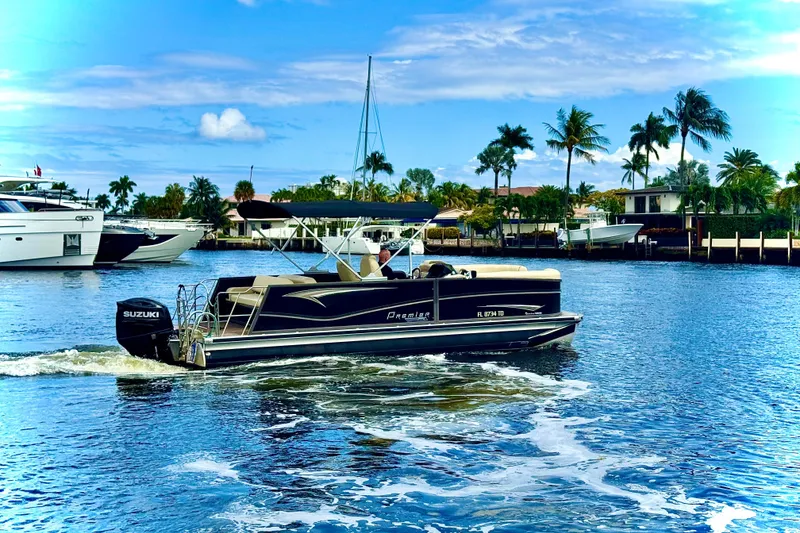 Slide: The Image of 2022 Premier Solaris 230 boat cruising on a sunny waterway with palm trees. - 71