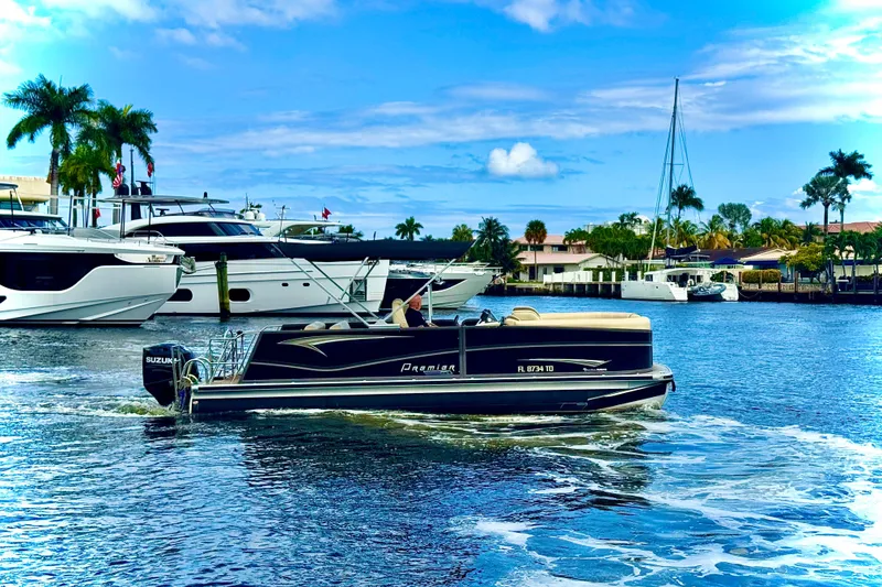 Slide: The Image of 2022 Premier Solaris 230 boat cruising on a sunny waterfront with palm trees. - 72