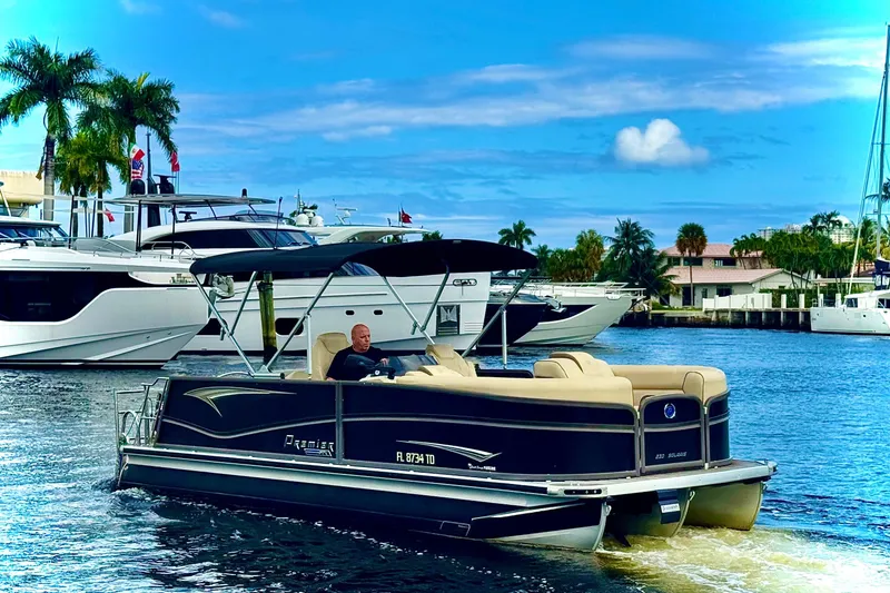 Slide: The Image of 2022 Premier Solaris 230 pontoon boat cruising in a scenic marina setting. - 75