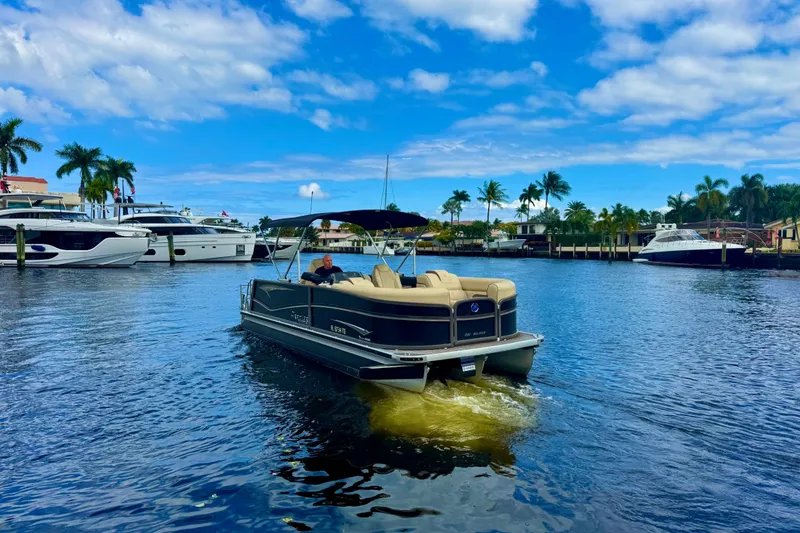 Slide: The Image of 2022 Premier Solaris 230 boat cruising on a sunny day with palm trees in the background. - 76
