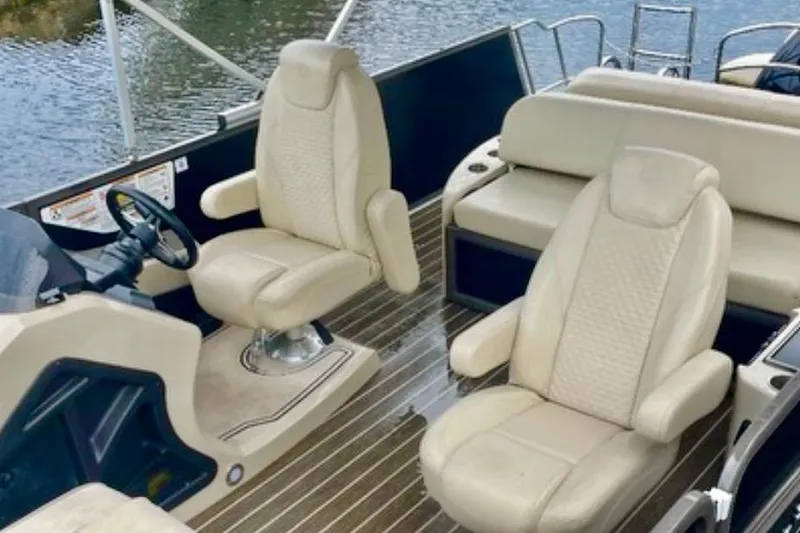 Slide: The Image of 2022 Premier Solaris 230 pontoon boat docked by a waterfront home. - 8